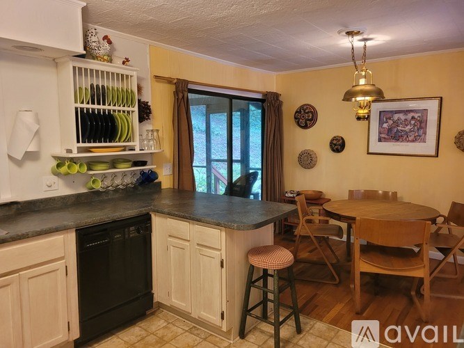 A kitchen with a table and chairs in front of a window.