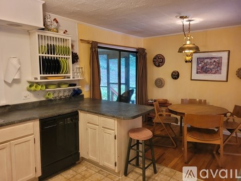 A kitchen with a table and chairs in front of a window.