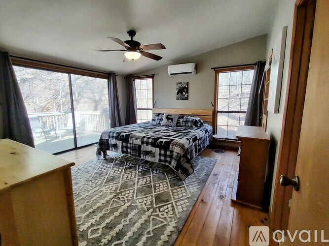 A bedroom with a bed, dresser, and sliding glass doors.