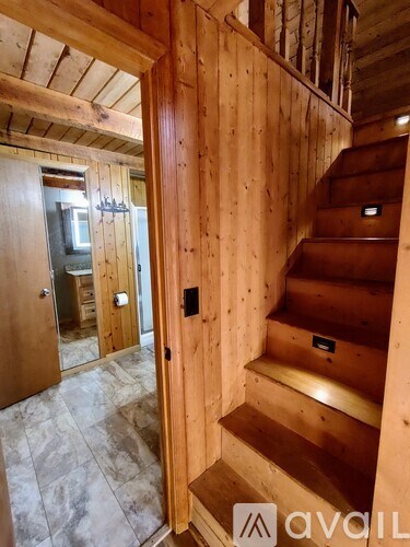 A wooden staircase with a black handle on the right side.