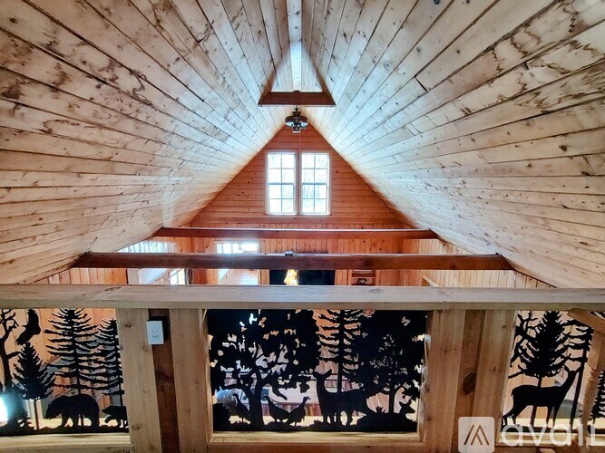 A wooden cabin with a window and a triangular roof.