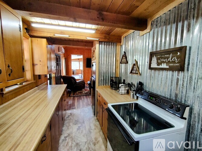 A kitchen with wooden cabinets and a stove top oven.