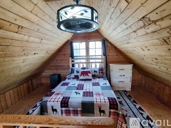 A bedroom with a bed, a window, and a ceiling fan.