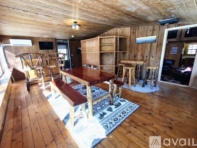 A wooden room with a long table and chairs.