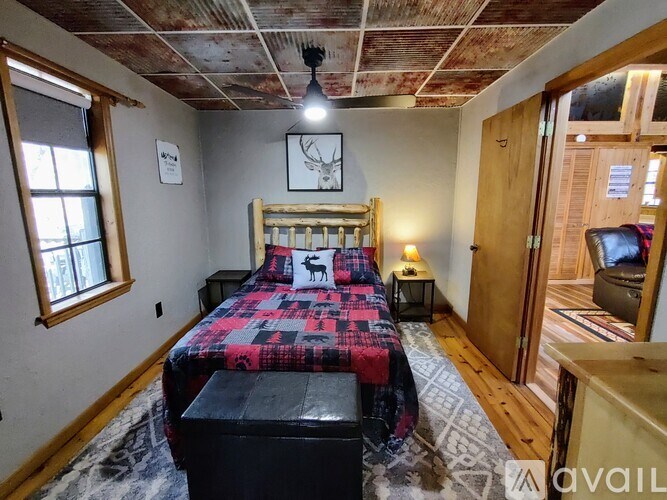 A bedroom with a bed, a bench, and a window.