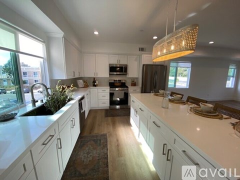 A modern kitchen with white cabinets and a large island.