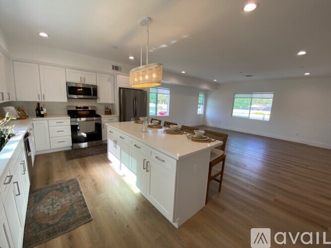 A kitchen with white cabinets and a wooden island.