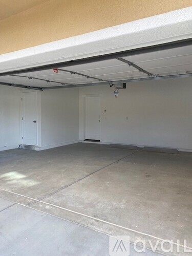 A spacious garage with a concrete floor and white walls.