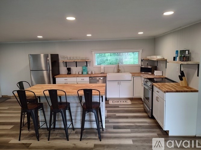 A kitchen with a table and chairs in front of it.