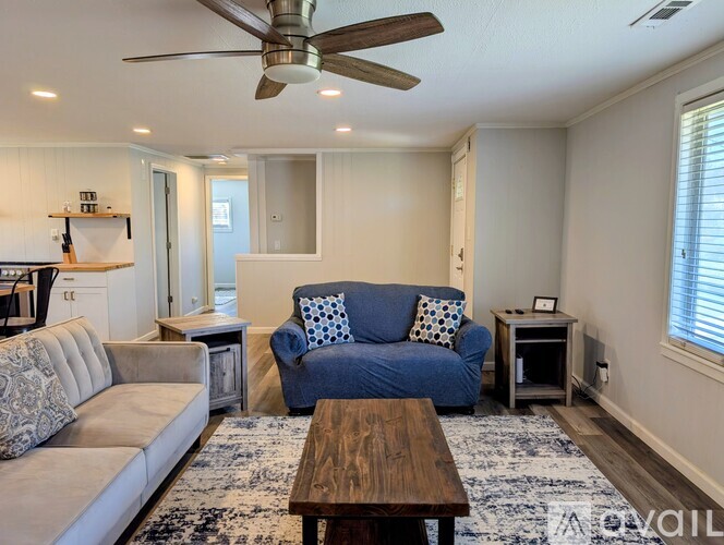 A living room with a brown leather couch and a wooden table.