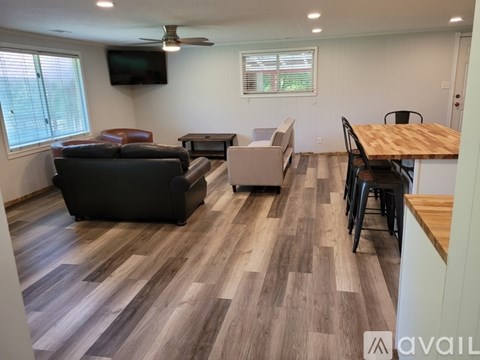 A living room with a brown leather couch and a wooden table.