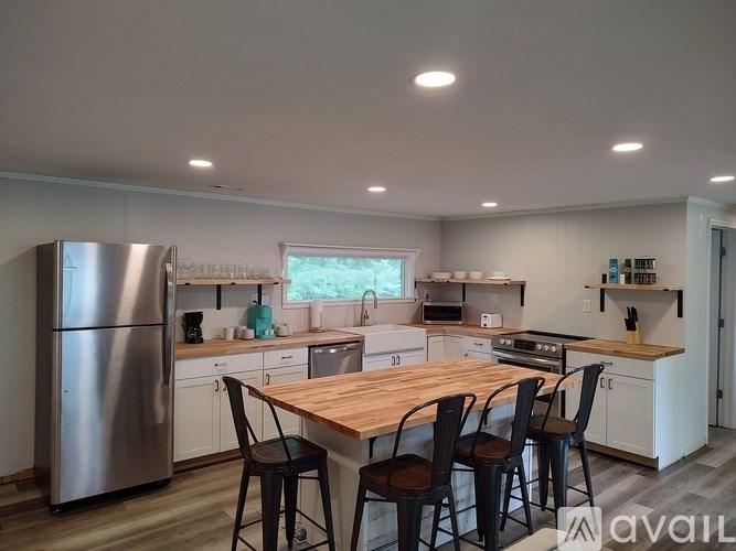 A kitchen with a table and chairs in front of a window.