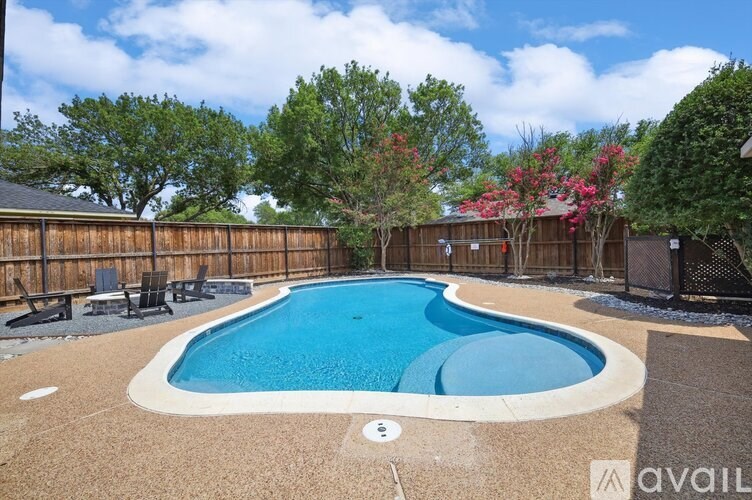 A small pool surrounded by a wooden fence and trees.