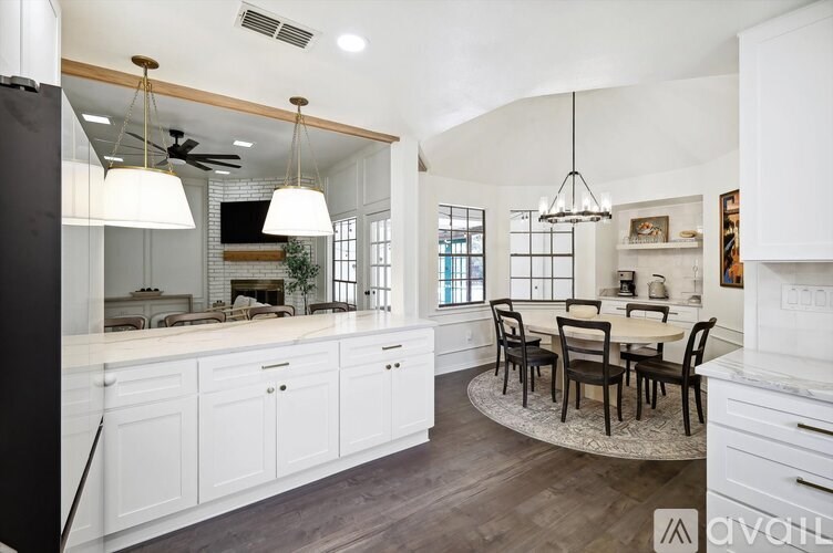 A kitchen with white cabinets and a black refrigerator.