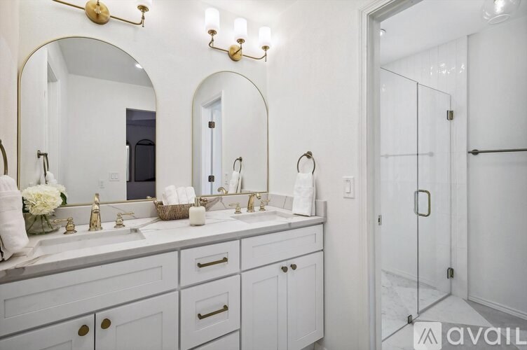 A bathroom with a double sink vanity and a large mirror.
