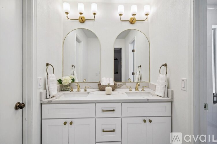 A bathroom with a white vanity and two sinks.