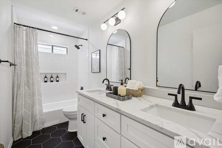 A bathroom with a white sink and a large mirror.