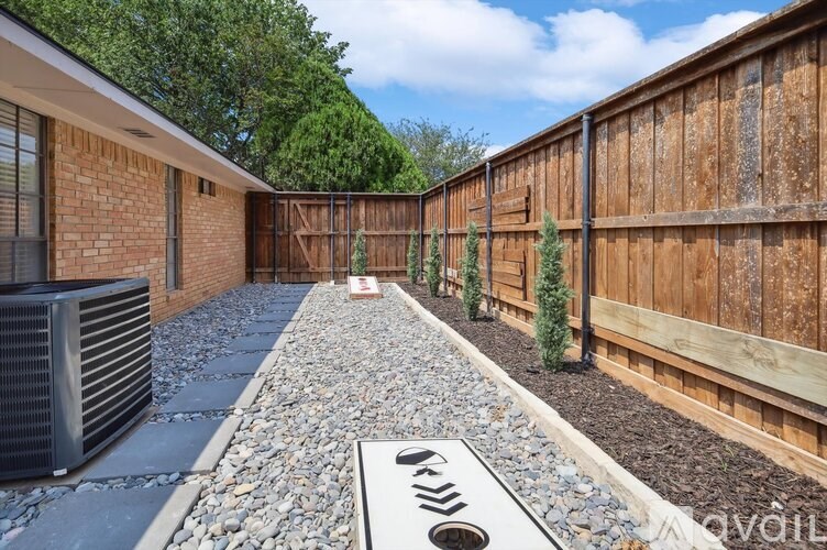 A backyard with a gravel path and a wooden fence.
