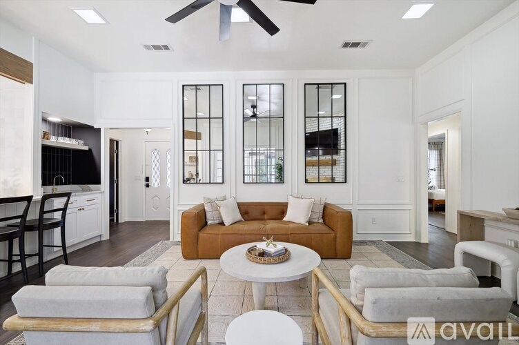 A living room with a brown couch and a white coffee table.