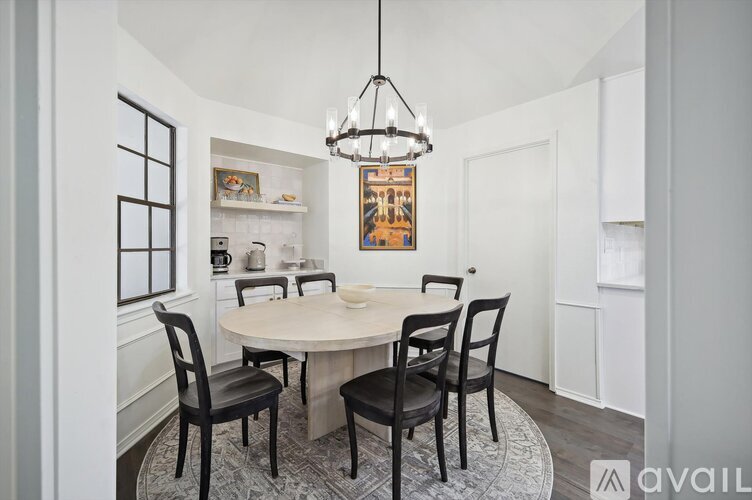 A dining room with a round table and chairs.