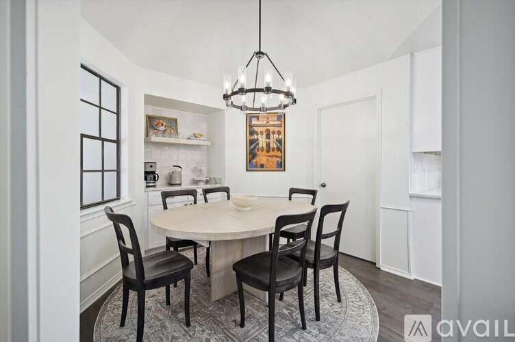 A dining room with a round table and chairs.