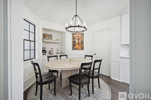 A dining room with a round table and chairs.