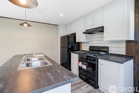 A kitchen with a stove top oven and a sink.