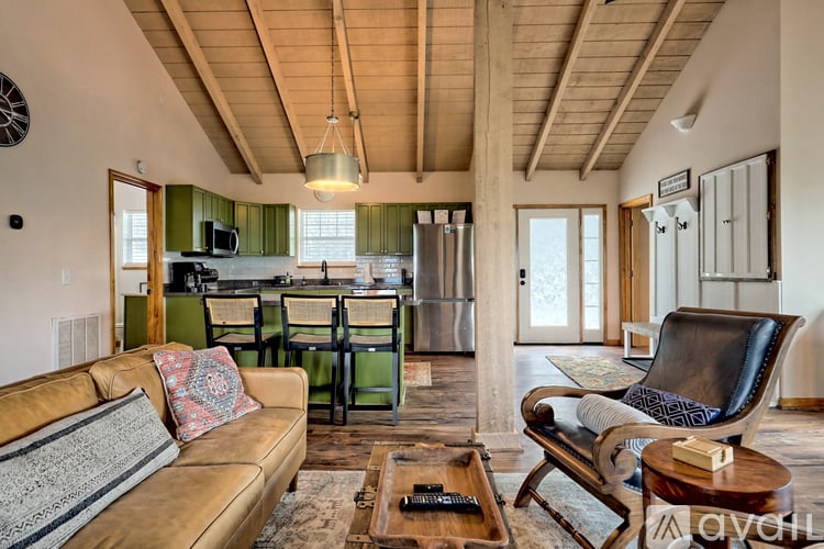 A living room with a tan couch and a black chair.