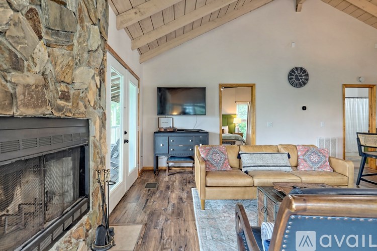 A living room with a stone fireplace and a couch.