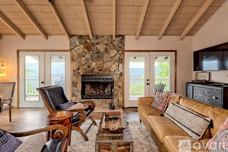 A living room with a stone fireplace and a couch.