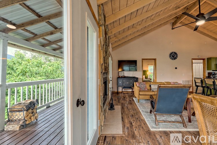 A wooden deck with a white door and a ceiling fan.