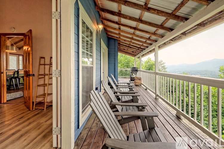 A balcony with wooden benches and a view of the mountains.