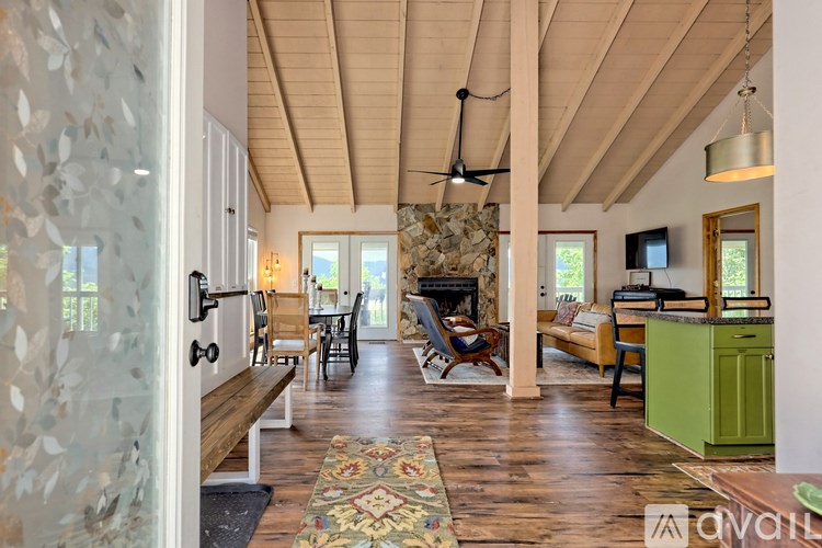 A living room with a wooden floor and a stone wall.