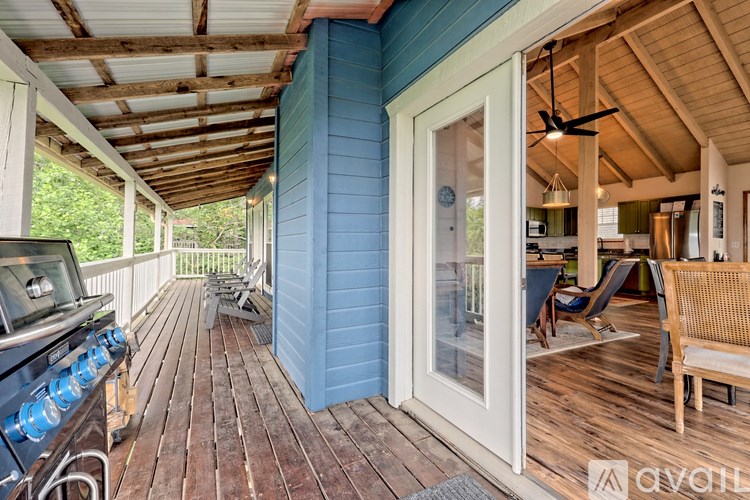 A wooden deck with a grill and chairs.
