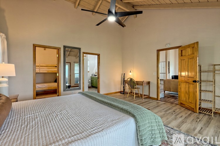 A bedroom with a large bed and a ceiling fan.
