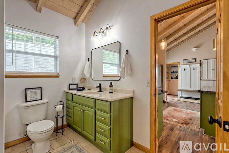 A bathroom with green cabinets and a white toilet.