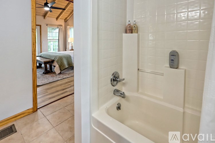 A bathroom with a white tub and a wooden door.
