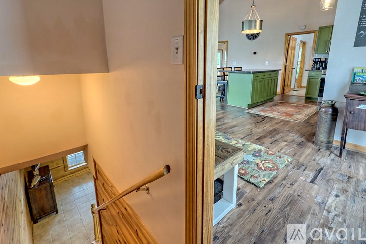 A view of a hallway leading to a kitchen and a staircase.
