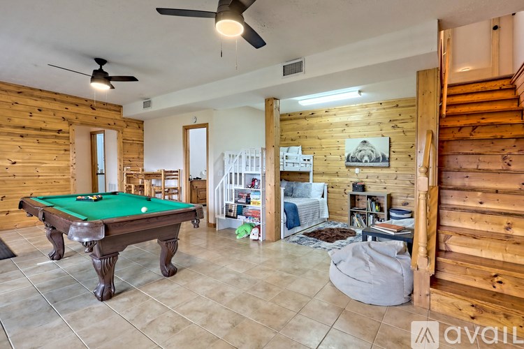 A room with a pool table and a green pool table cloth.