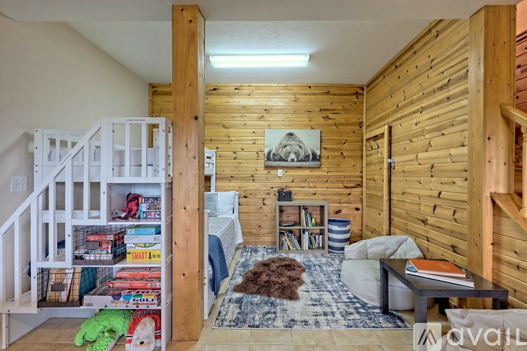A cozy bedroom with wooden walls and a bunk bed.