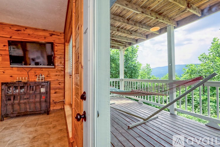 A wooden cabin with a deck outside.