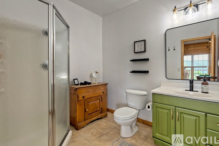 A bathroom with a toilet, sink, and shower.