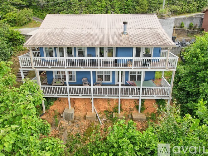 A blue house with a white fence and a balcony.
