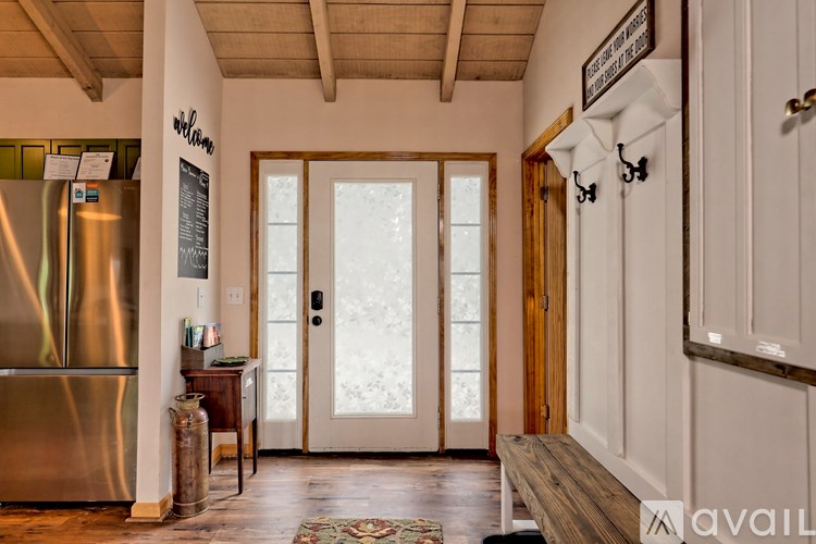 A kitchen with a wooden floor and a stainless steel refrigerator.