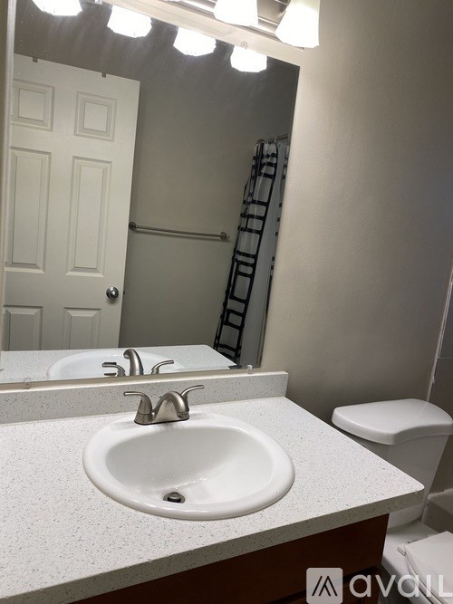 A white sink in a bathroom with a mirror above it.