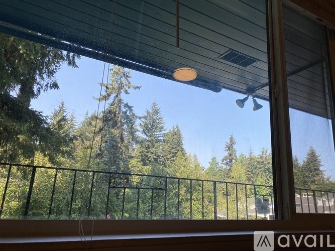 A balcony with a view of trees and a clear sky.