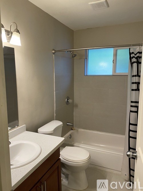 A bathroom with a toilet, sink, and bathtub.