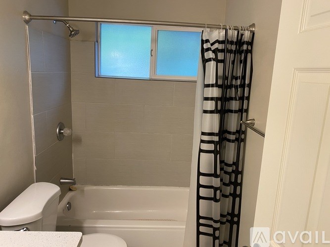 A bathroom with a toilet, bathtub, and shower.