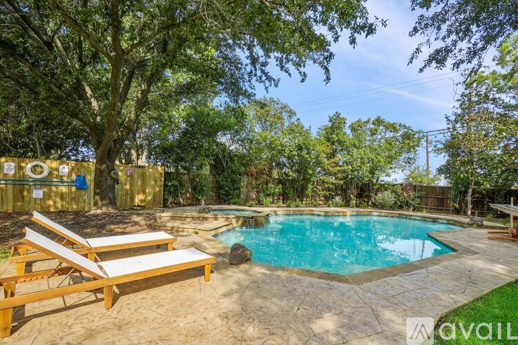 A pool surrounded by trees and a wooden deck.