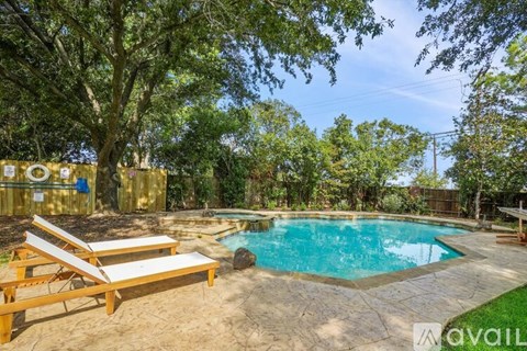 A pool surrounded by trees and a wooden deck.